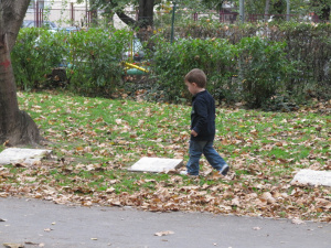 Мальчик скачет по плитам на кладбище